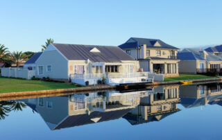 White single story houses beside body of water