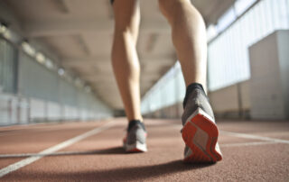 Fit runner standing on racetrack in athletics arena