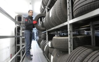 Man in black jacket standing beside black tires