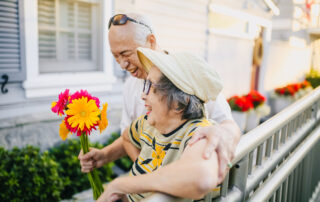 Elderly man giving colorful flowers to his wife