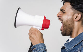 Man in blue denim jacket holding a megaphone