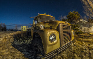 Rusty truck on grassy meadow at night