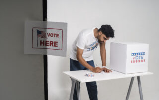 A man voting beside a ballot box