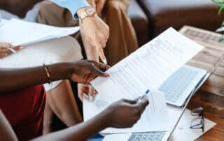 Multiethnic businesswomen checking information in documents